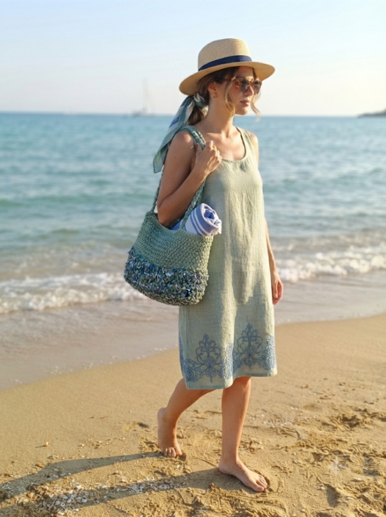 Borsa Verde Mare portata a spalla in riva al mare con abito verde salvia e cappello